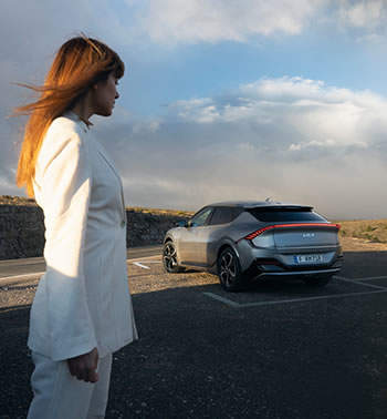White clad woman in front of a EV6