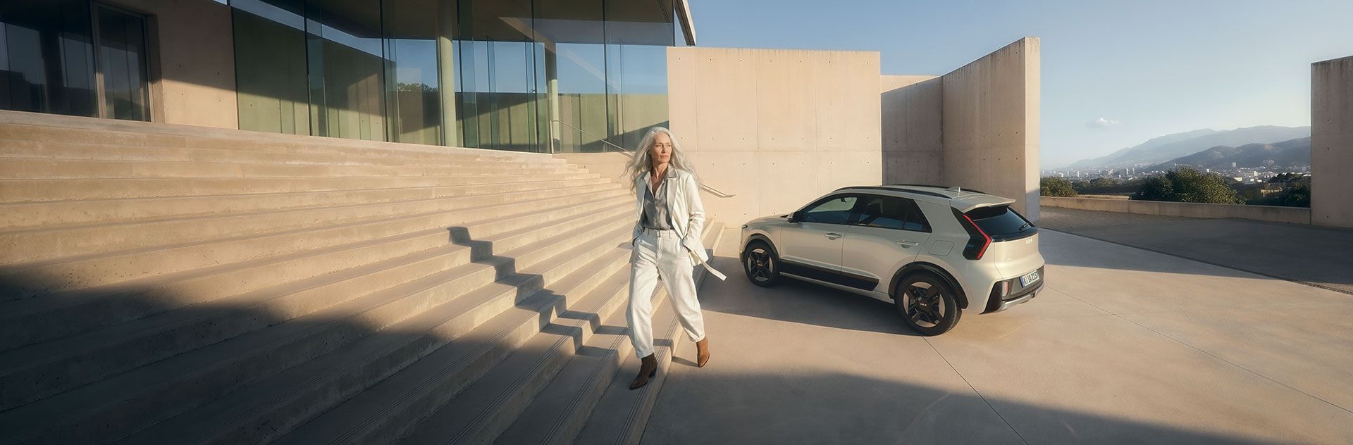 Mujer delante de un Kia Niro