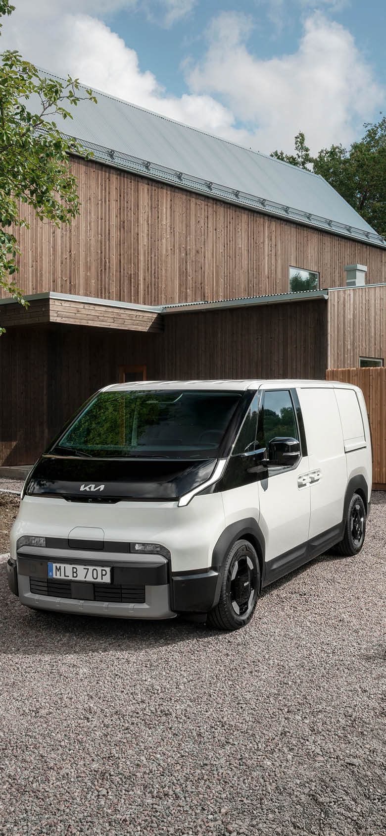 Kia PV5 Cargo ssedd snett framifrån vid ett bostadshus.