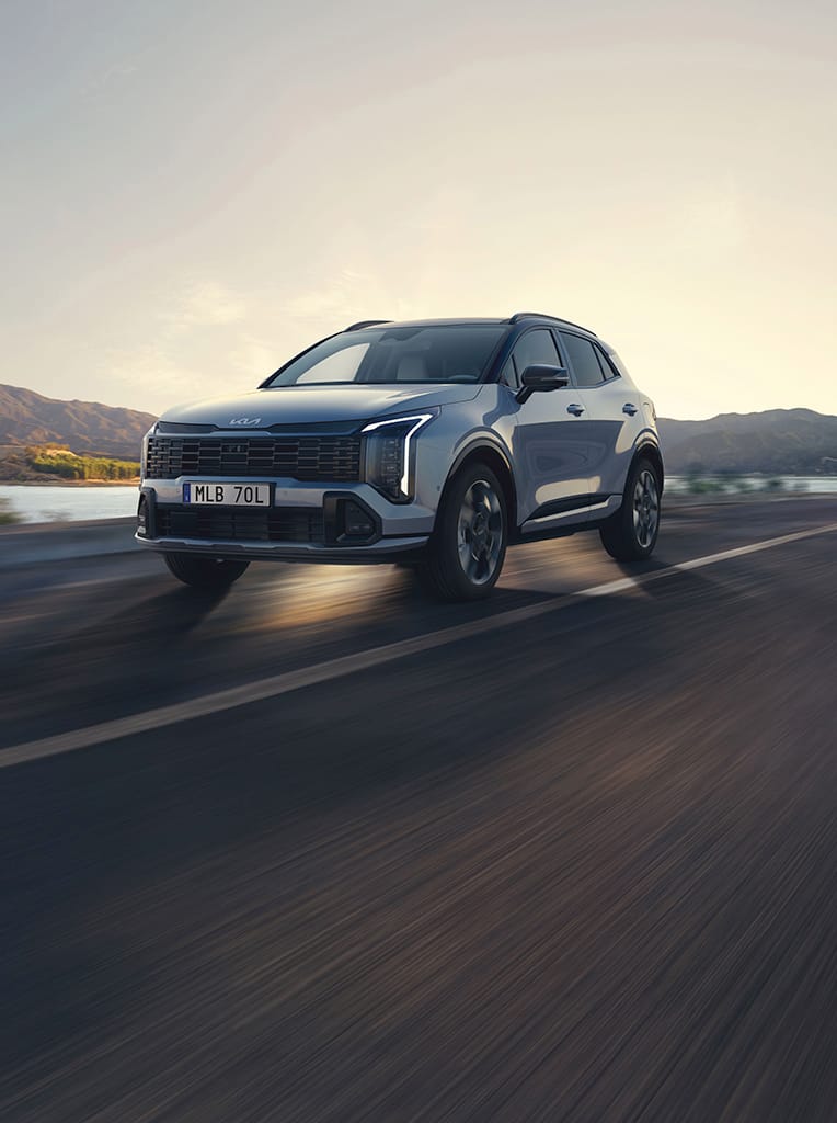 Kia Sportage som kör på en landsväg.