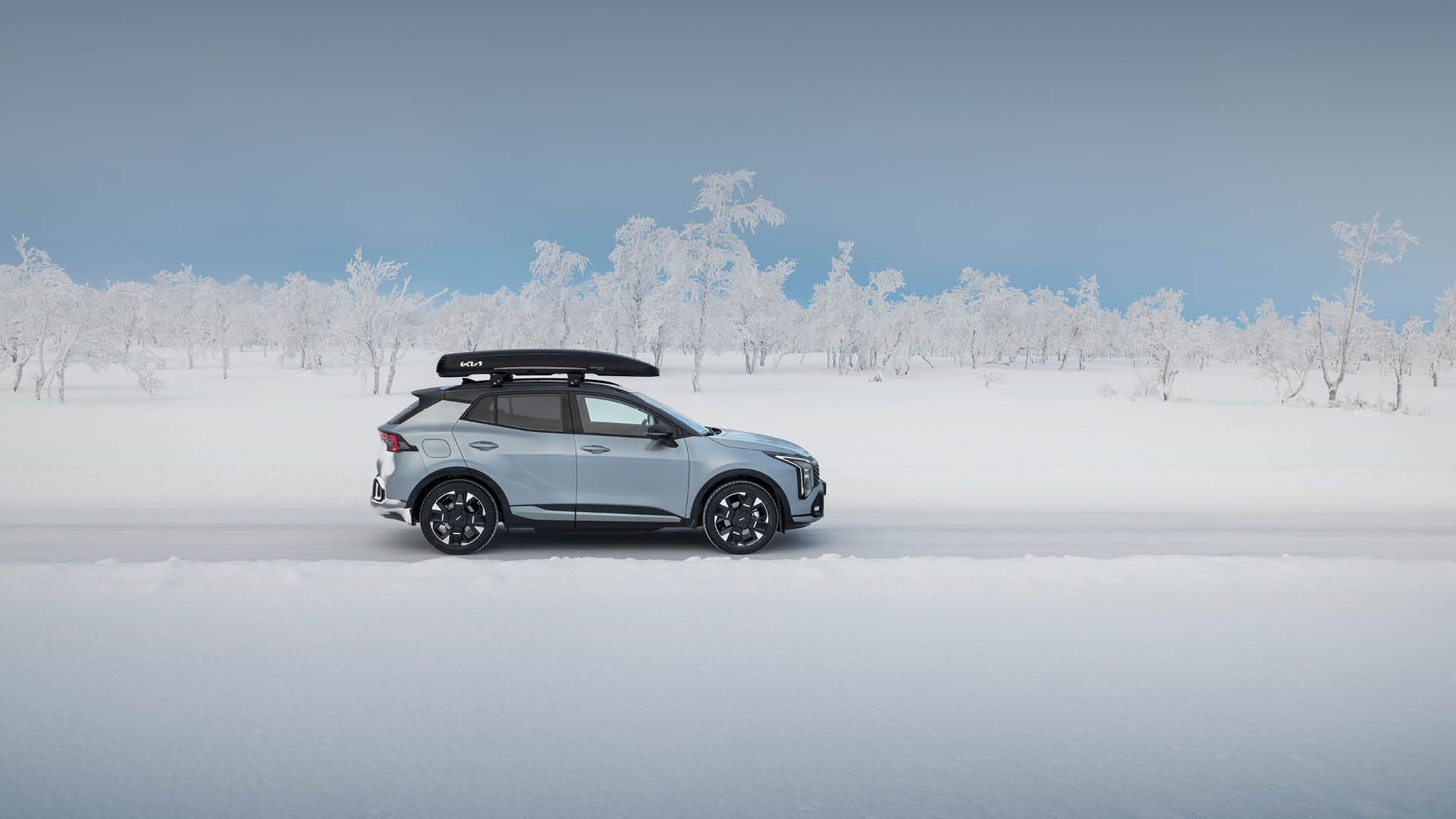 Kia Sportage i profil i ett vinterlandskap.