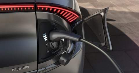 Kia electric car external socket plugged into plug-in charging cable 