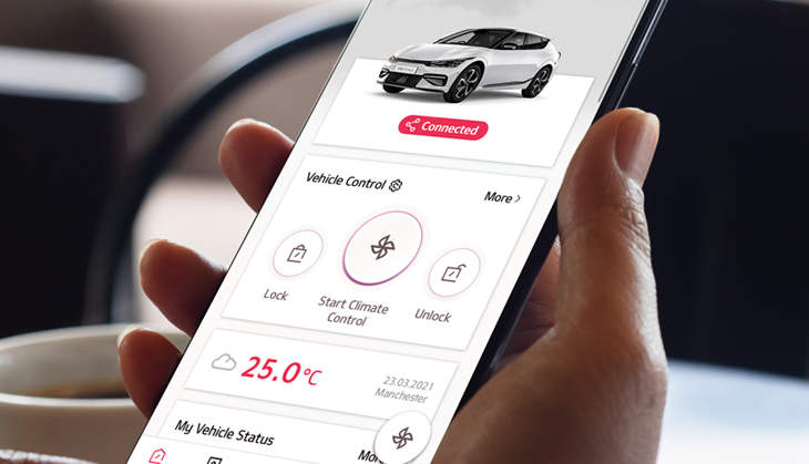 A person navigating a Kia in car technology from the palm of their hand with Kia Connect app