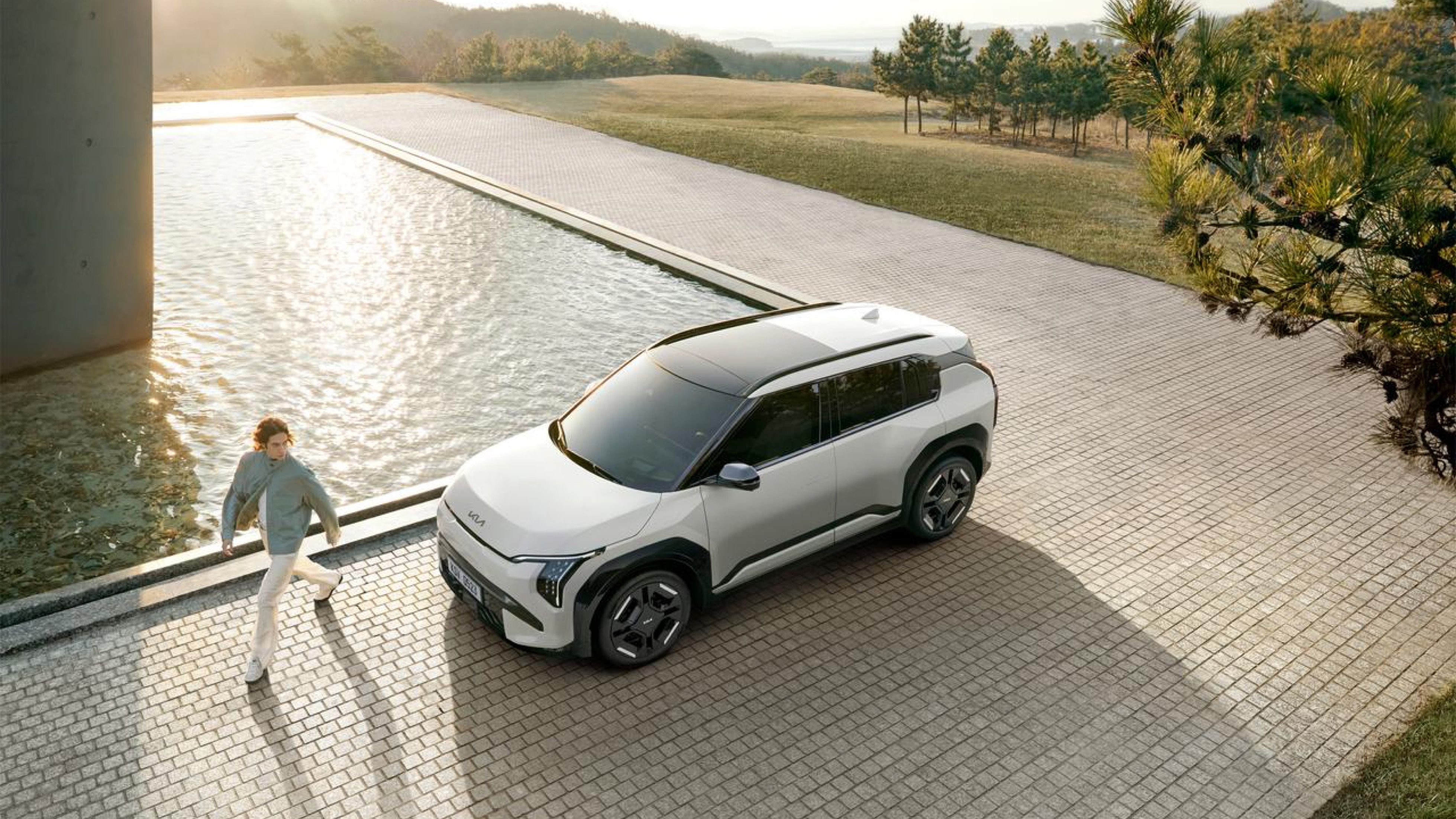 A man looking back at a EV3 GT-Line S in White Pearl