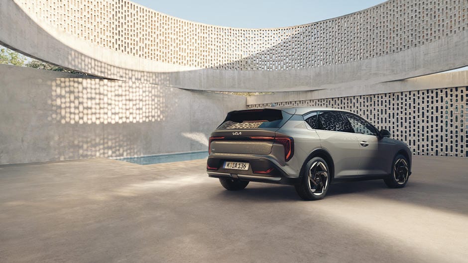 The Kia K4 parked by a curved wall