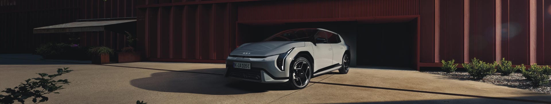 The Kia EV4 parked near a brown building