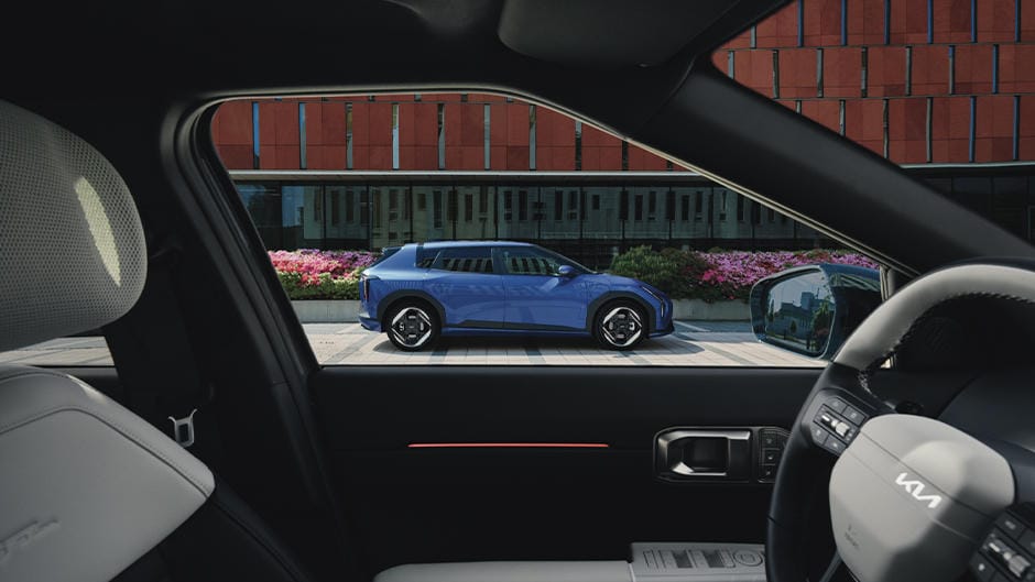 The Kia EV4 parked infront of a brown building