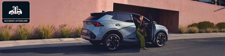 Kia electric vehicle charging via a home charging point, with 'Kia Accident Aftercare' stamp