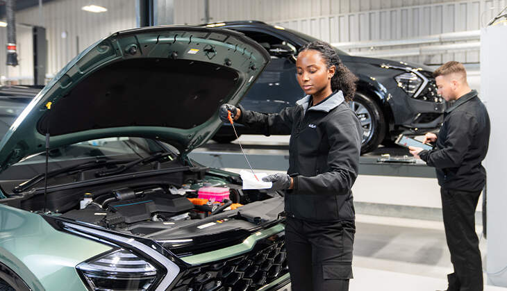 Kia technician providing servicing and maintenance replacements on a Kia car.  