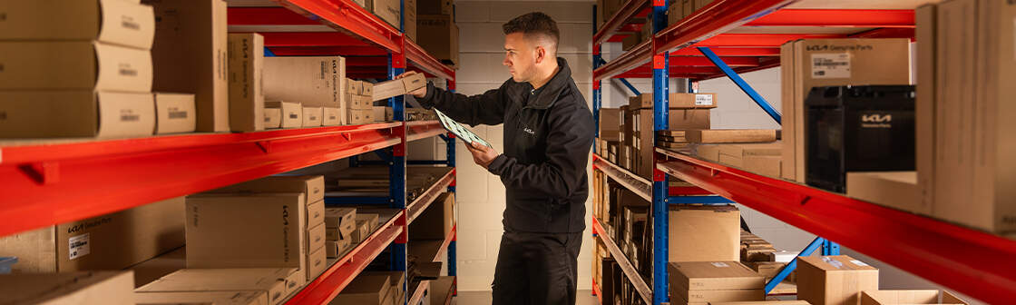A man stands in a warehouse surrounded by shelves filled with boxes