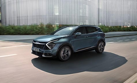 Sportage driving along a sunny city road
