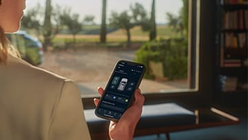 Driver with Kia Connect app on smartphone in EV9 interior