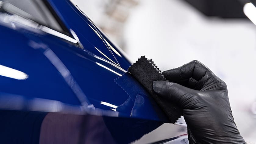 A close-up of a person applying ceramic coating on car