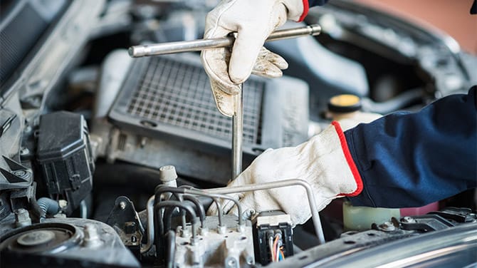 Mechanic repairing a car using a wrench