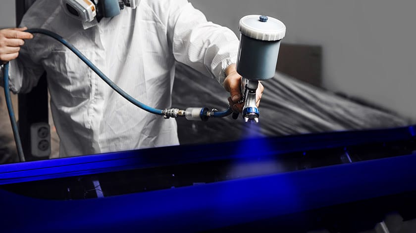 Specialist sprays dye on the elements part of car