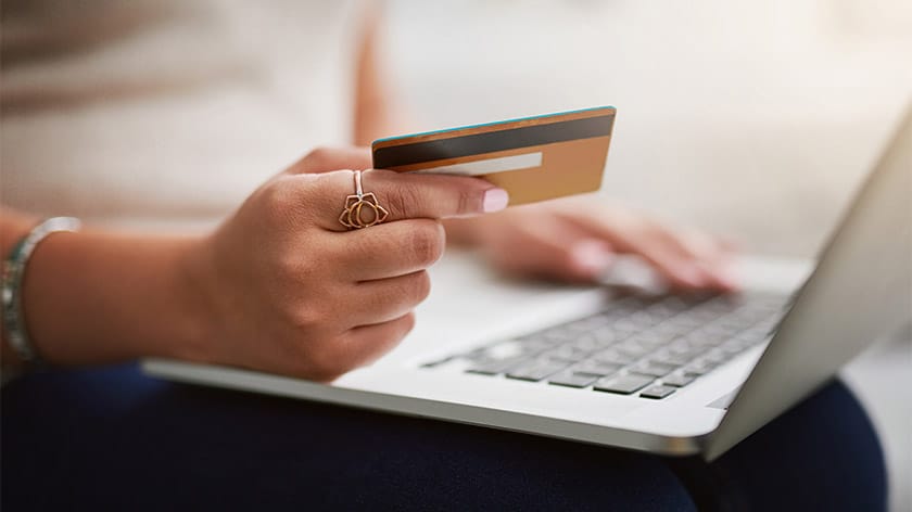 Woman holds creidt card and smartphone pay bills on-line