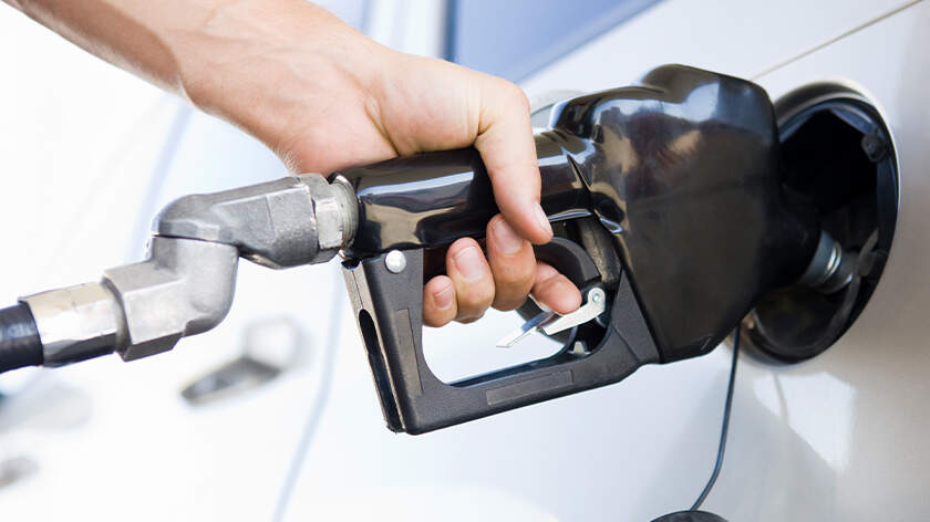 Close-up of a hand pumping gas into a car