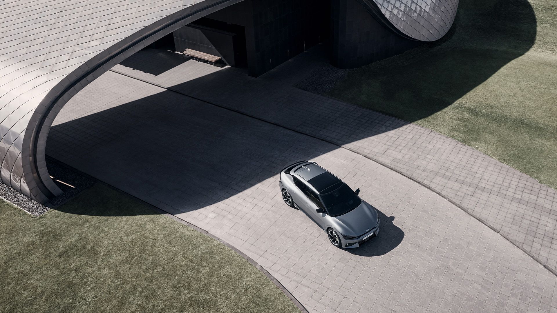 سيارة EV6 تسير ببطء بالقرب من مبنى معماري حديث