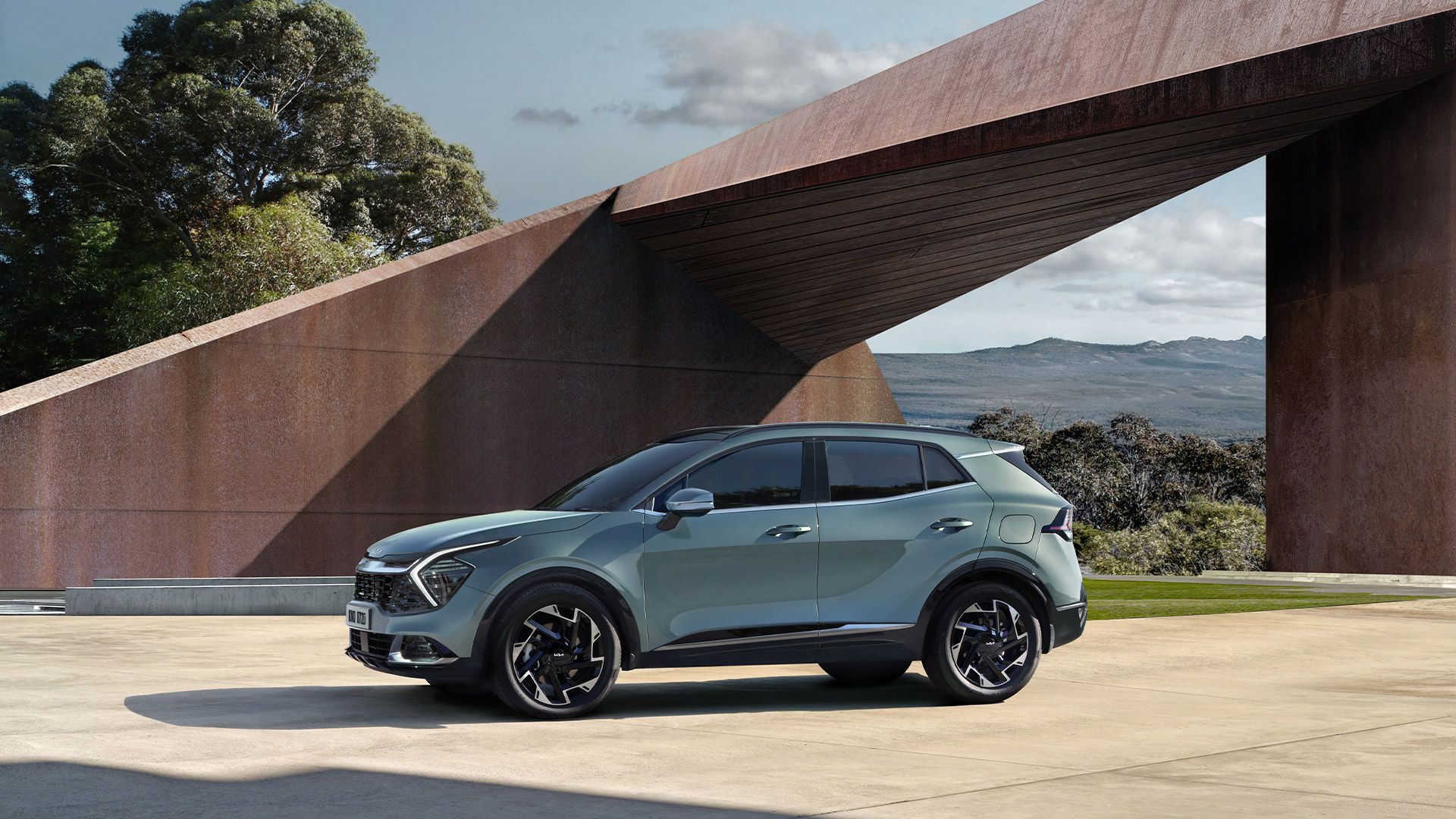 سيارة كيا سبورتاج متوقفة أمام هيكل معماري تجريدي.