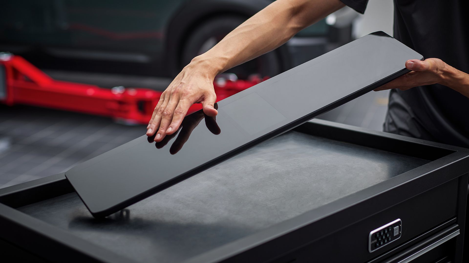 فني يتعامل مع قطعة غيار أصلية من كيا على صندوق أدوات الخدمة