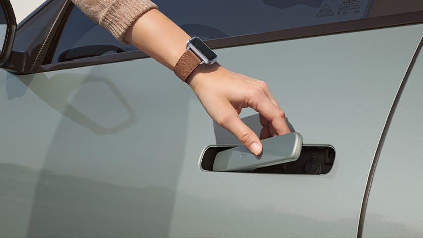 Hand wearing a smartwatch unlocking the vehicle door using a digital key