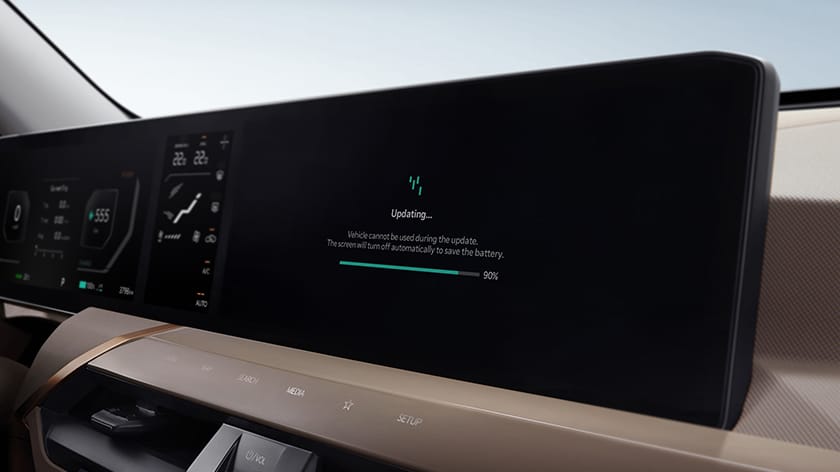 Vehicle cockpit with the infotainment screen showing a software update in progress