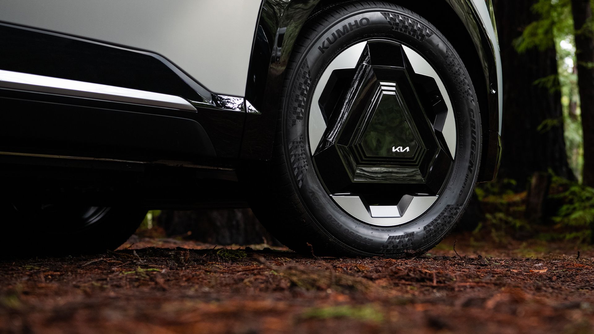 Close-up of a Kia EV9 wheel on a forest trail
