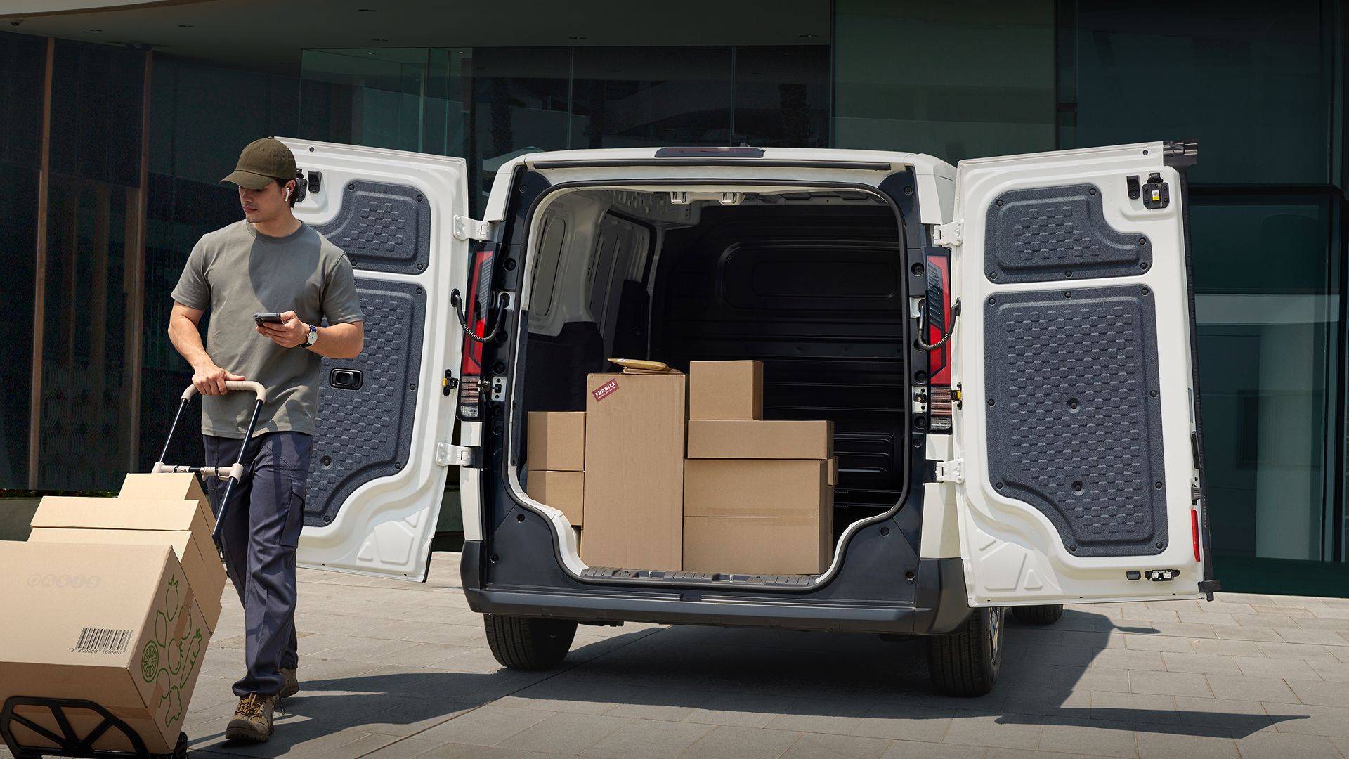 Delivery worker unloading boxes from the Kia PV5 Cargo rear