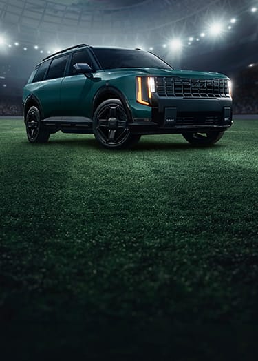 Kia Telluride HEV parked on a stadium pitch under dramatic floodlights, celebrating Kia's FIFA partnership