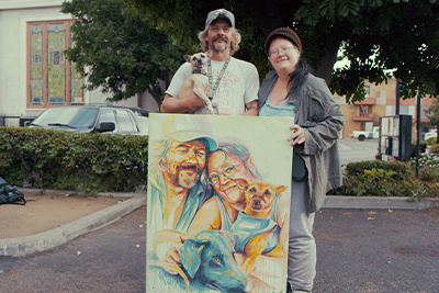 Two Homeless People Pose With Their Portrait Painted By Brian Peterson
