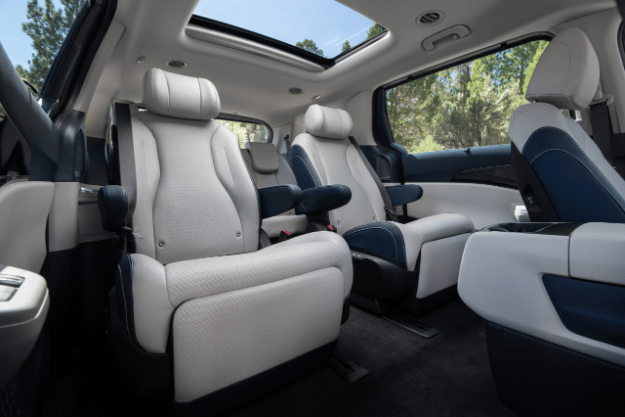 2025 Kia Carnival MPV Hybrid interior, three-quarter view of the VIP Lounge Seats with the footrests down