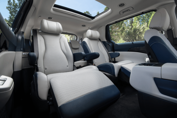 2025 Kia Carnival MPV Hybrid interior, three-quarter view of the VIP Lounge Seats with the footrests up