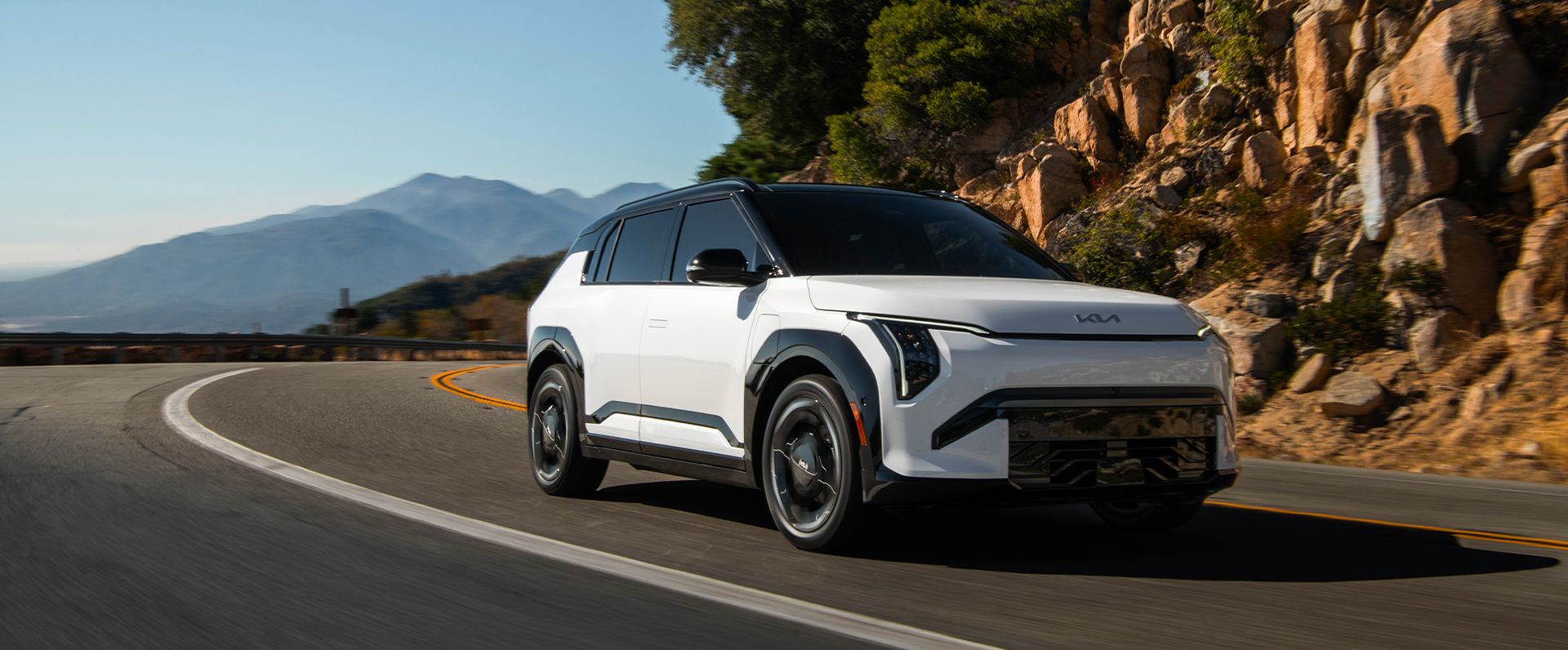 The all-new 2027 Kia EV3 compact electric SUV on a coastal mountain road
