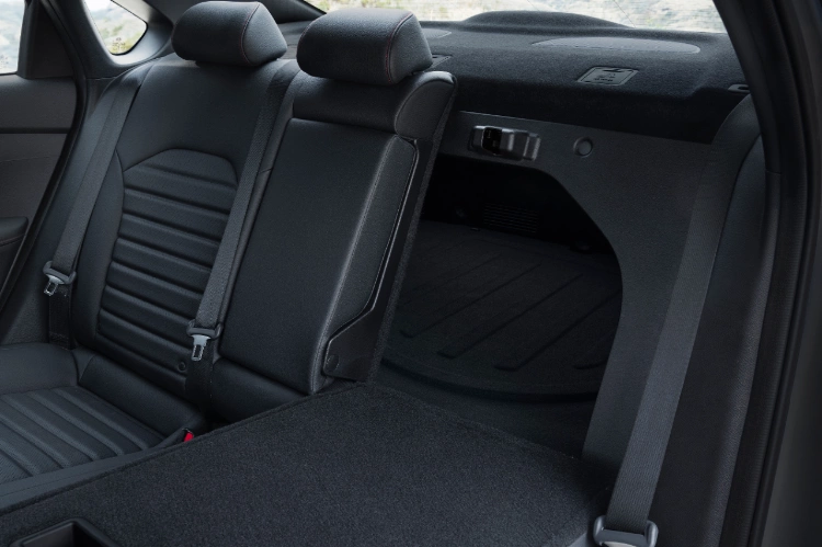 2022 Kia Forte with black interior, close-up of rear seats with lowered left seat for trunk access