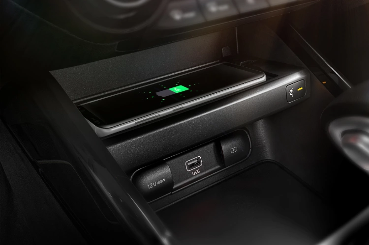 2022 Kia Forte, close-up of center console technology highlighting wireless charging smartphone shelf and USB-A compatibility