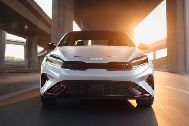 2023 Kia Forte Driving Beneath A Highway Underpass at Sunrise Front View