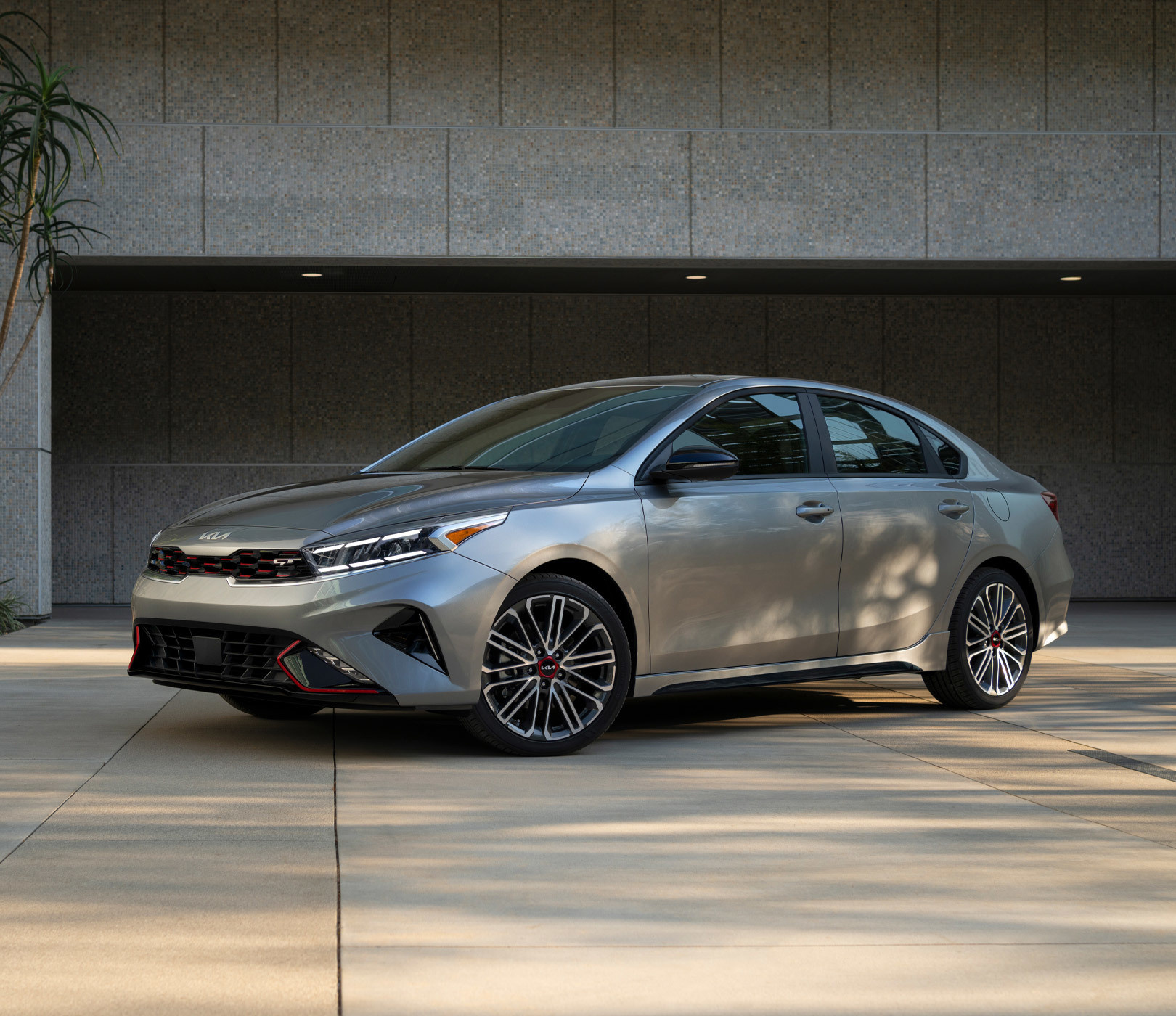 2023 Kia Forte With A Sleek Design Parked In Front Of A Garage - Three-Quarter View