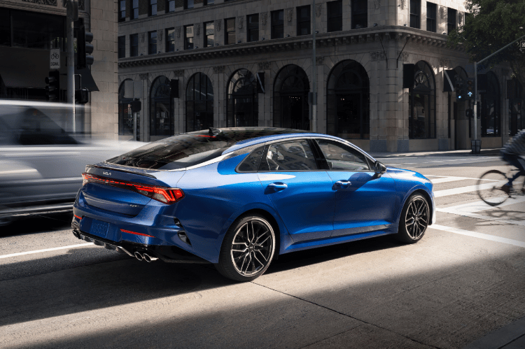 2022 Kia K5 Driving In A City Rear Three-Quarter View
