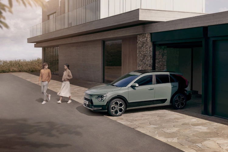 2023 Kia Niro Hybrid Parked In Front Of A House Near The Garage Three-Quarter View