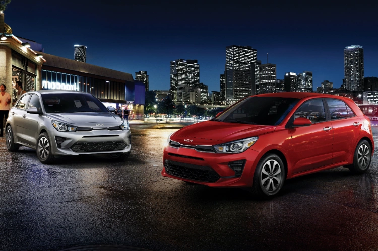 2022 Kia Rio 5-Door Red And Silver Vehicles Parked In Front Of A City At Night