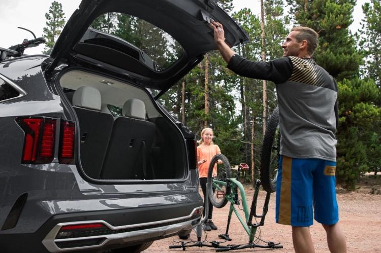 Propietarios del Kia Sorento Hybrid 2024 usando la puerta trasera inteligente para sacar su equipo de campamento