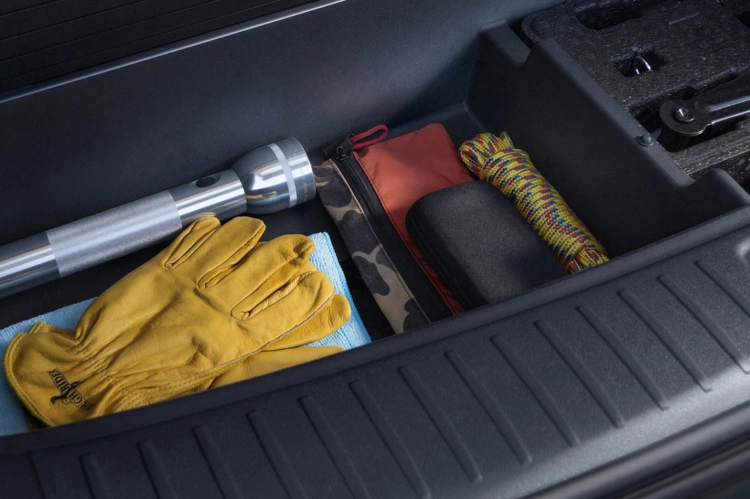 Primer plano del kit de emergencia para autos en carretera equipado con guantes, una linterna y herramientas esenciales
