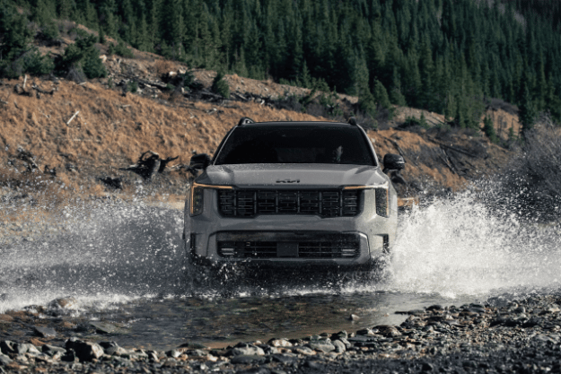 2025 Kia Sorento, front view, driving through a river making a big splash