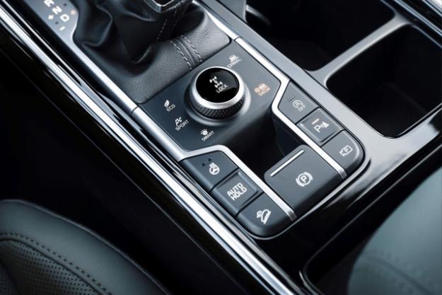 2025 Kia Sorento X-Pro SX Prestige AWD interior, zoomed in view of the driver center console with the snow mode button and parking assist button pressed on