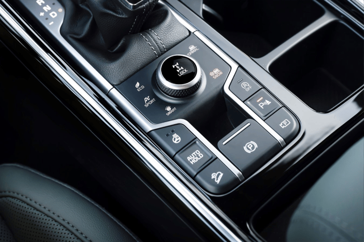 2025 Kia Sorento X-Pro SX Prestige AWD interior, zoomed in view of the driver center console with the snow mode button and parking assist button pressed on
