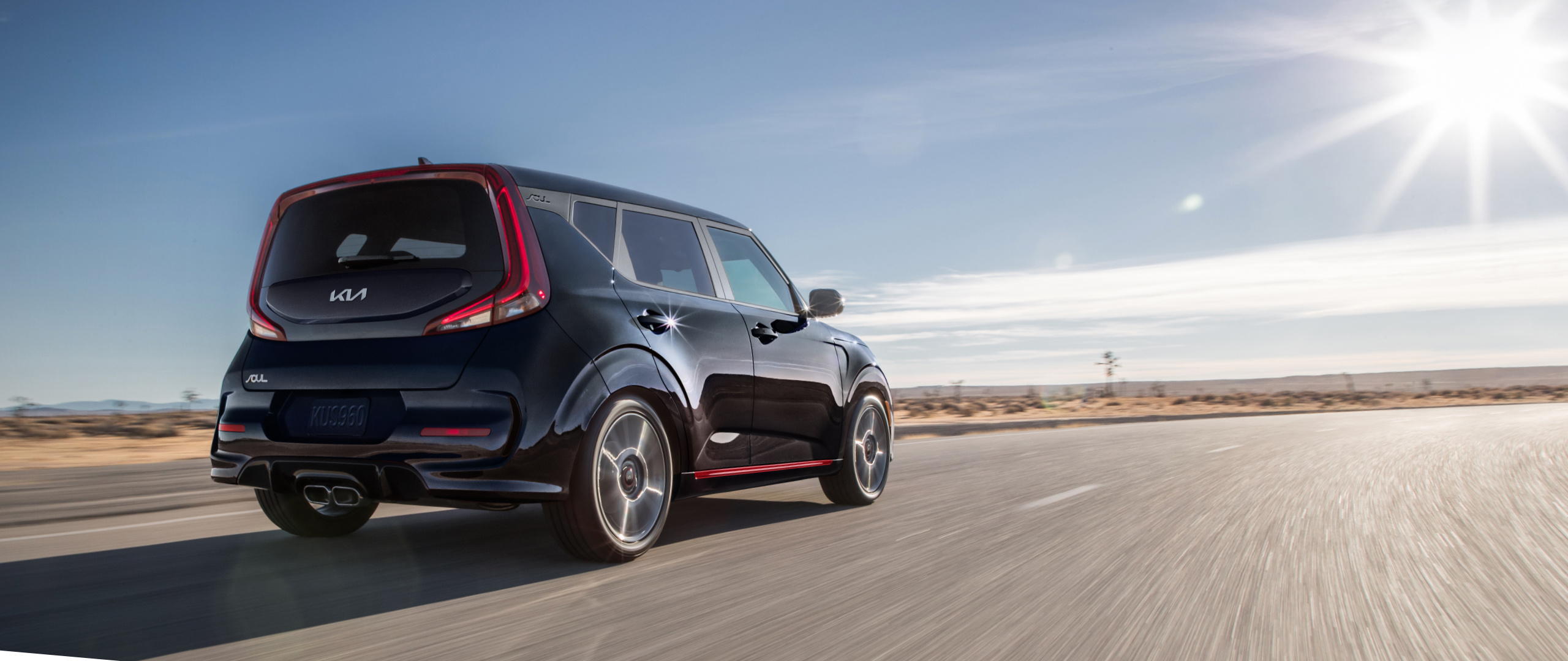 2022 Kia Soul Driving On An Open Road In The Desert Rear Three-Quarter View