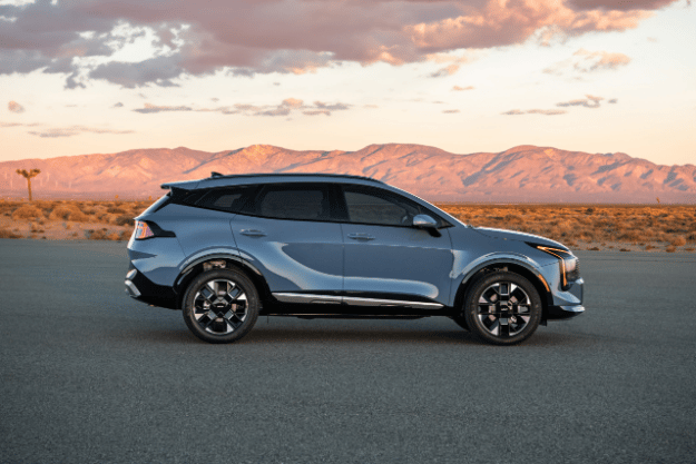 Vehículo Sportage 2026 en vista lateral, estacionado sobre pavimento en el desierto