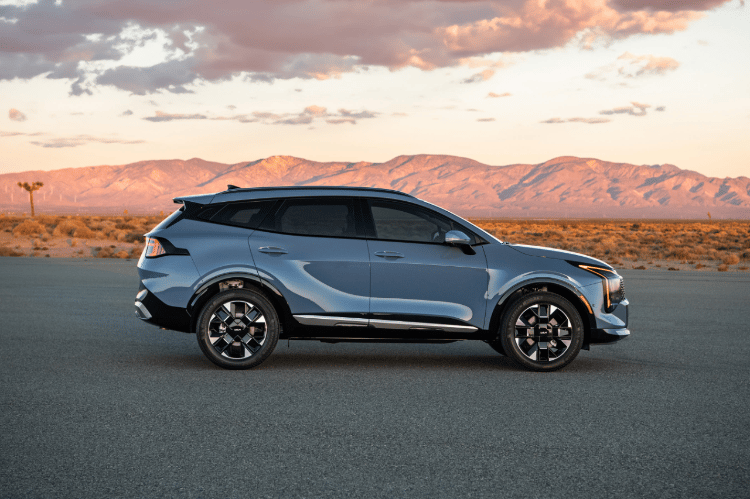 Vehículo Sportage 2026 en vista lateral, estacionado sobre pavimento en el desierto