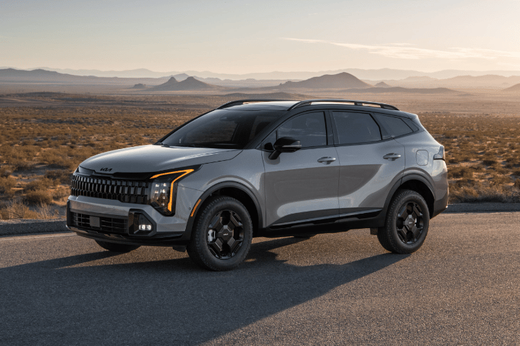 Vehículo Sportage 2026 en vista tres cuartos frontal, estacionado en un camino desértico