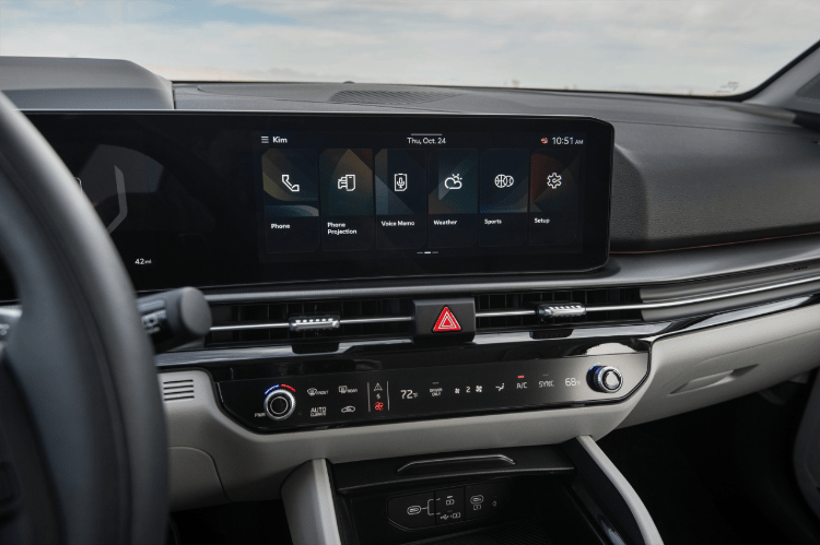 Vehículo Sportage 2026, pantalla panorámica doble con iconos como teléfono, nota de voz y configuración en la pantalla